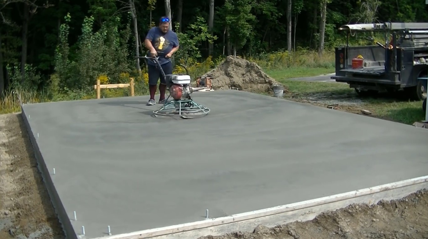 Professional contractor using power trowel to finish concrete slab